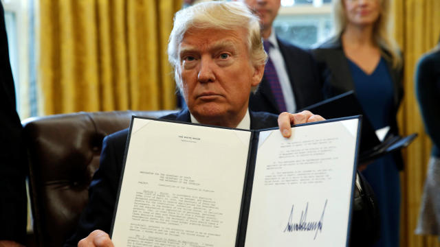 President Trump holds up a signed executive order to advance construction of the Keystone XL pipeline at the White House in Washington Jan. 24, 2017. 