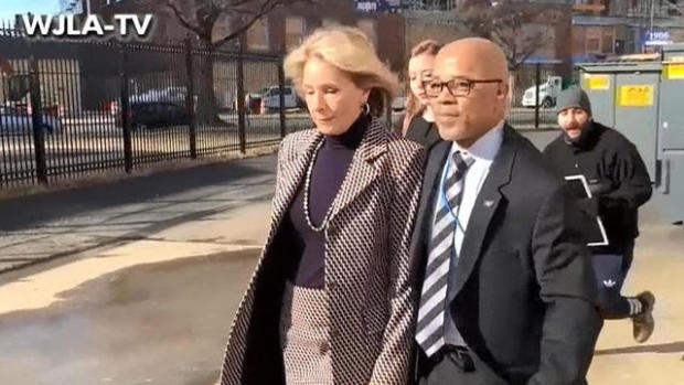 Education Secretary Betsy DeVos walks with a bodyguard to a SUV after protesters blocked her from entering Jefferson Middle School in Washington, D.C., on Feb. 10, 2017. 