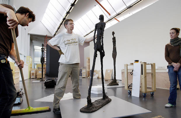 Employees at the Kunsthal museum in Rotterdam, Netherlands, adjust the sculpture “Walking Man” by Swiss artist Alberto Giacometti on Oct. 15, 2008. 