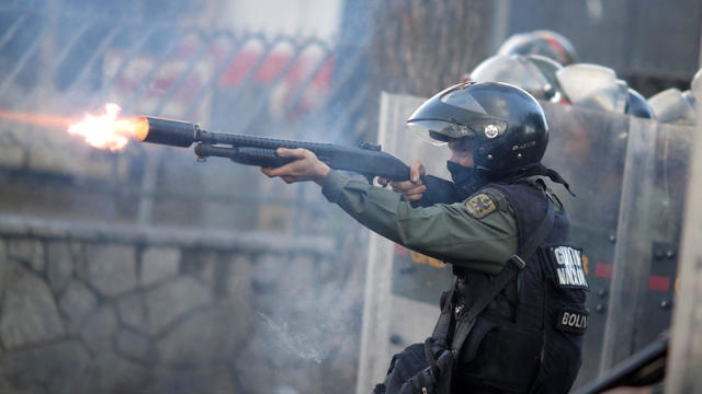 A riot security force member fires his weapon at a rally during a strike called to protest against Venezuelan President Nicolas Maduro's government in Caracas, Venezuela, July 26, 2017. 