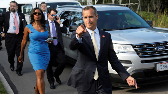 Former Trump campaign manager Corey Lewandowski, center, says hello to reporters as he and, from left, White House advisers Sebastian Gorka and Omarosa Manigault and then-White House communications director Anthony Scaramucci accompany President Trump for 