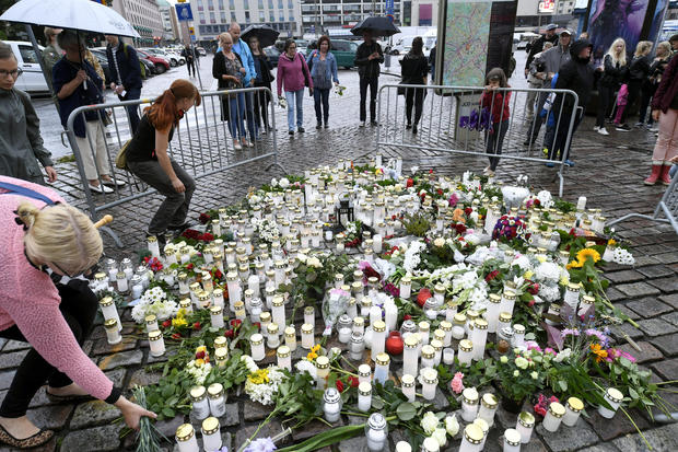 People bring memorial candles and flowers to the Turku Market Square for the victims of Friday's stabbings in Turku 