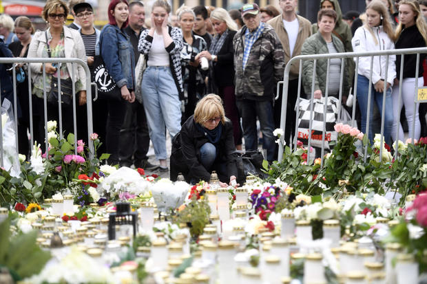 Mourners bring memorial candles and flowers to the Turku Market Square 