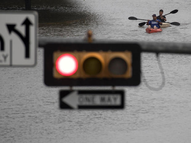 Men use kayaks to get through an intersection after heavy rain from Hurricane Harvey flooded Pearland, in the outskirts of Houston 
