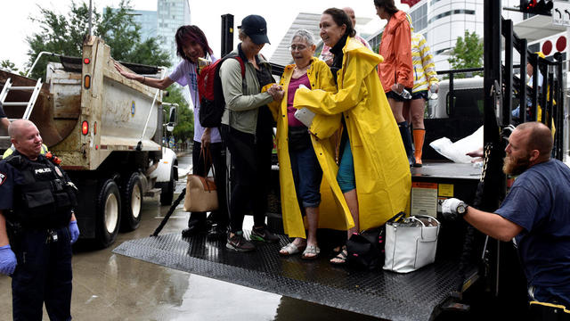 Evacuees are unloaded from the back of an open bed truck at the George R. Brown Convention Center after Hurricane Harvey inundated the Texas Gulf coast with rain causing widespread flooding, 