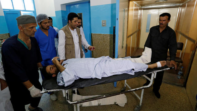 An injured man is carried inside a hospital after a suicide attack in Kabul 