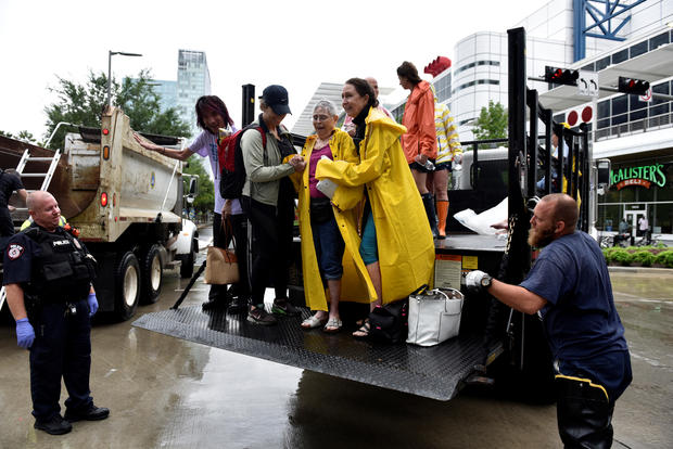 Evacuees are unloaded from the back of an open bed truck at the George R. Brown Convention Center after Hurricane Harvey inundated the Texas Gulf coast with rain causing widespread flooding, 