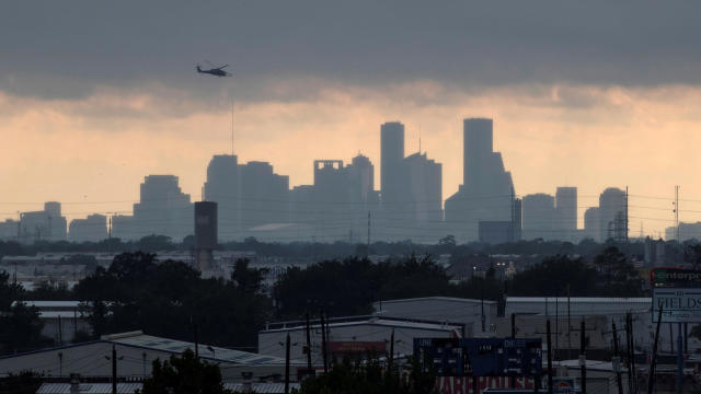 A helicopter hovers above the Houston skyline as sunlight breaks through storm clouds from Tropical Storm Harvey in Texas Aug. 29, 2017. 