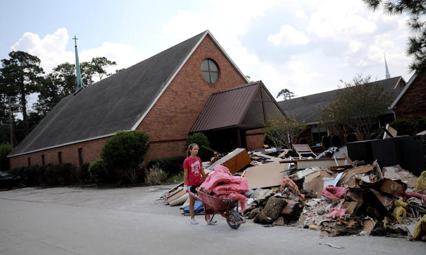 A volunteer helps clean up the damage from a Lutheran church in the aftermath of Tropical Storm Harvey in Dickinson, Texas 