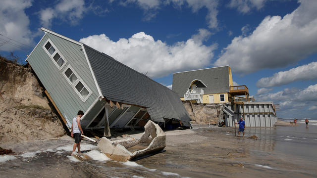 Local residents look at a collapsed coastal house after Hurricane Irma passed the area in Vilano Beach 