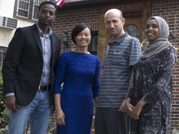 Abdi Iftin, left, of Somalia; Uyen Nguyen, second from left, of Vietnam; Eiman Ali, right, of Somalia but born in Yemen; and Ghassan al-Chahada of Syria pose for a photo outside President Trump's boyhood home in the Jamaica Estates neighborhood of the Que 