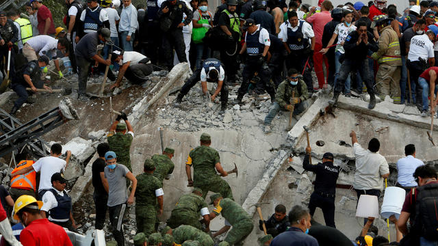 Rescue workers and people carry donations of bottled water and food after an earthquake in Mexico City 