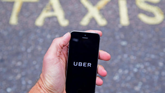 FILE PHOTO: A photo illustration shows the Uber app logo displayed on a mobile telephone, as it is held up for a posed photograph in central London 