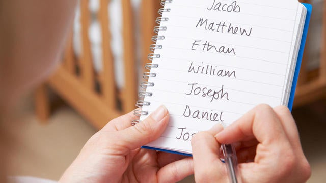 Woman Writing Possible Names For Baby Boy In Nursery 