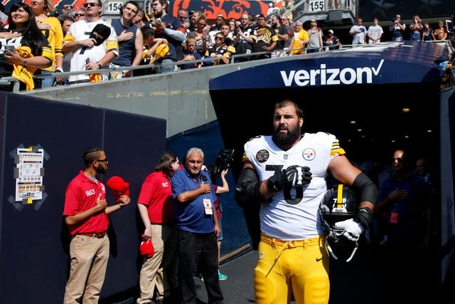 Two Patriots players hold up fists after national anthem