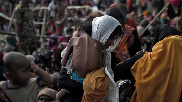 A woman carries her ill child in a refugee camp at Cox's Bazar 