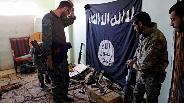 Fighters of Syrian Democratic Forces inspect weapons and munitions recovered at the former positions of the Islamic State militants inside a building at the frontline in Raqqa 