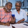 Couple using calculator in kitchen 