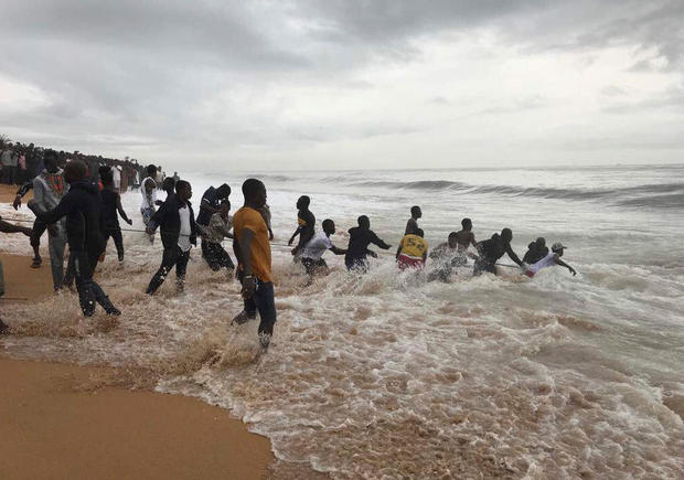 People rush to pull the wreckage of a propeller-engine cargo plane is seen after it crashed in the sea near the international airport in Ivory Coast's main city, Abidjan 