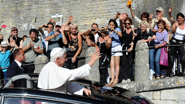 Pope Benedict XVI (C) waves to the faith 