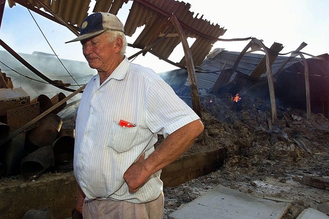 Farm owner Neville Tapson walks through the burnin 