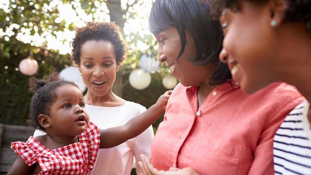 Multi generation female family members gathered in a garden 