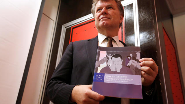 Boris Dittrich from  Human Rights Watch poses with a report in Hong Kong 