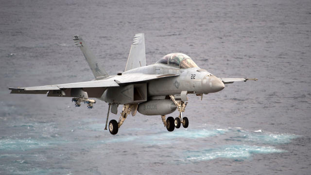 U.S. Navy crew members stand by an EA-18G Growler electronic warfare aircraft on the deck of the Nimitz-class aircraft carrier USS Carl Vinson during a South Korea-U.S. joint military exercise in seas east of the Korean Peninsula on March 14, 2017. 