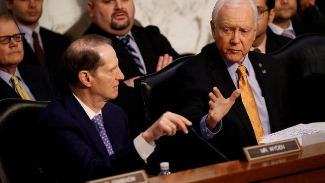 Sen. Orrin Hatch (R-UT) speaks with Sen. Ron Wyden (D-OR) during a markup on the "Tax Cuts and Jobs Act" on Capitol Hill in Washington 