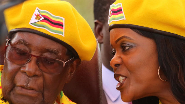FILE PHOTO: President Robert Mugabe listens to his wife Grace Mugabe at a rally of his ruling ZANU(PF) party in Harare 