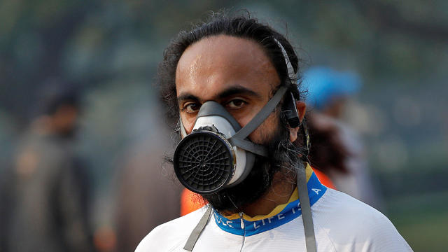 A runner wearing a face mask looks on as he takes part in the Airtel Delhi Half Marathon in New Delhi 