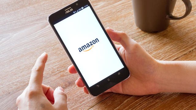 man hand holding screen shot of Amazon application 