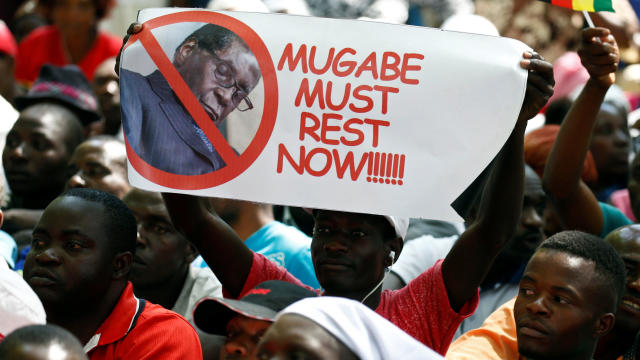A protester holds a placard calling for Zimbabwean President Robert Mugabe to resign outside  parliament in Harare 