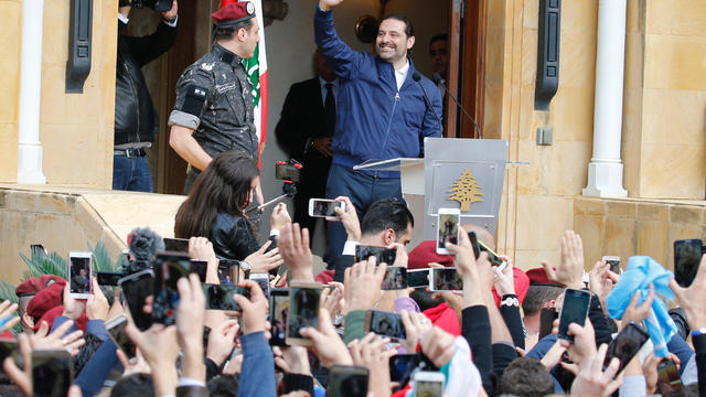 Saad al-Hariri who suspended his decision to resign as prime minister gestures to his supporters at his home in Beirut 