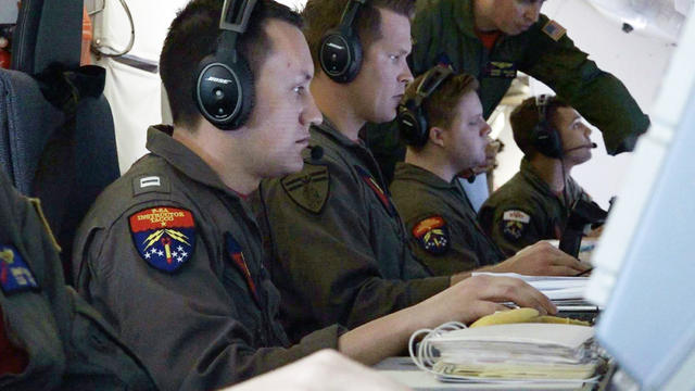 U.S. Navy flight officer Collver, mission commander at the Boeing P-8A Poseidon aircraft, works alongside other officers during the search for the ARA San Juan submarine missing at sea as they fly over the South Atlantic Ocean 