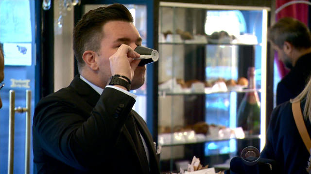 A man drinks a coffee beverage in a Milan, Italy, coffee shop. 