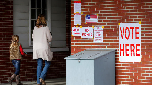 Anna Atkinson walks into a polling station with her 8-year-old daughter Tori, in Gallant 