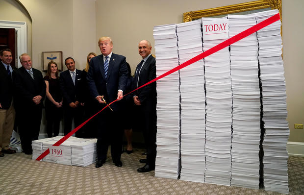 U.S. President Donald Trump cuts a red tape while speaking about deregulation at the White House in Washington 