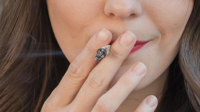Younger woman smoking a marijuana cigarette 