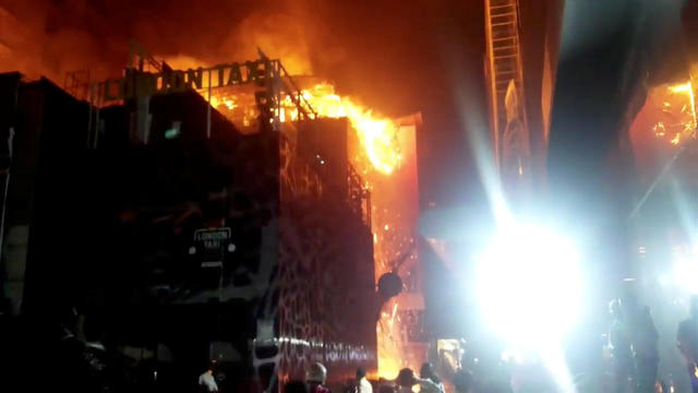 Debris falls from a building on fire in Mumbai, India 