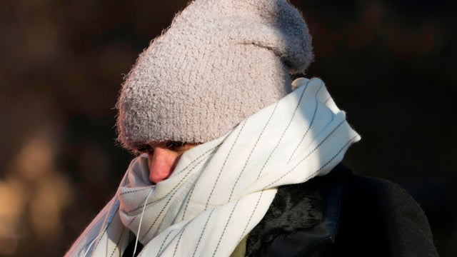 A woman bundles up against the cold temperature as she runs in New York 