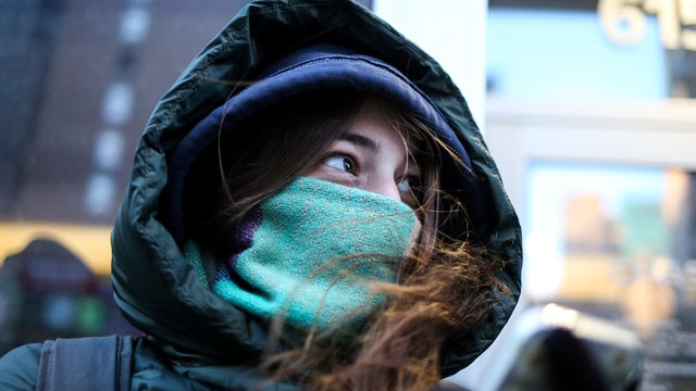 A woman bundles up against the cold temperature as she walks in New York 