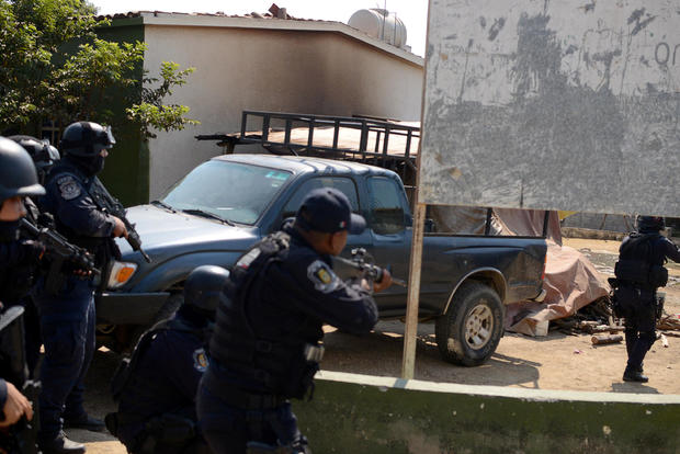 Police officers arrive near where an exchange of gunfire took place between residents and members of a local, self-appointed community police force which according to local media, left 11 dead in La Concepcion 