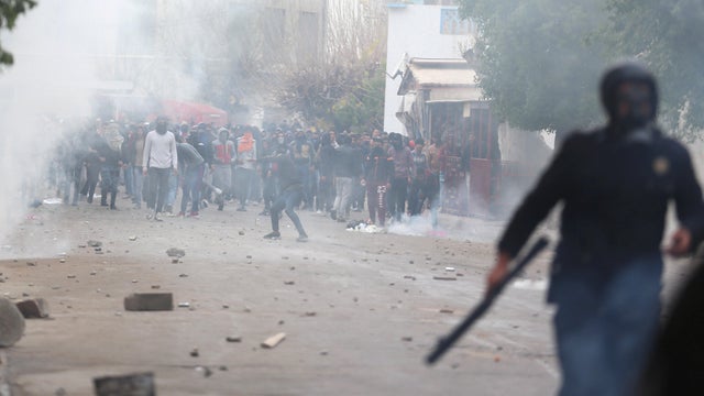 Tear gas is seen as protesters clash with riot police attempting to disperse the crowd during demonstrations against rising prices and tax increases, in Tebourba 