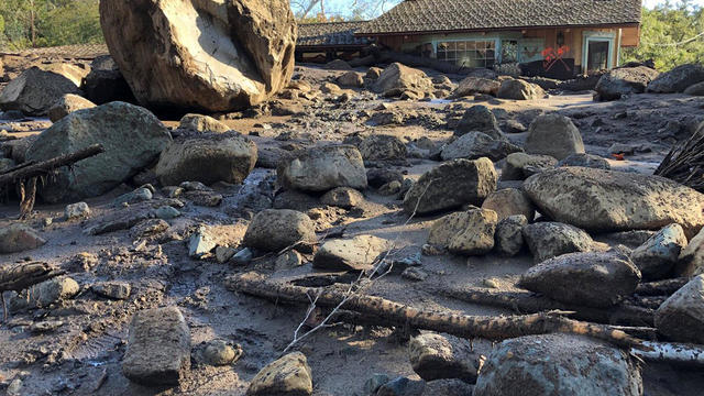 A damaged house is surrounded by large boulders and debris following mudslides due to heavy rains in Montecito 