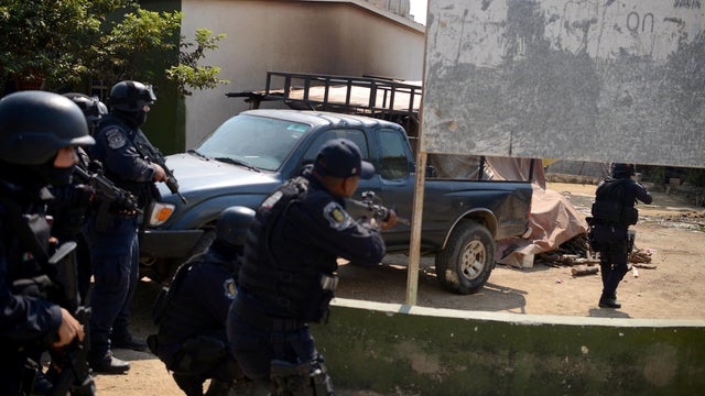 Police officers arrive near where an exchange of gunfire took place between residents and members of a local, self-appointed community police force which according to local media, left 11 dead in La Concepcion 