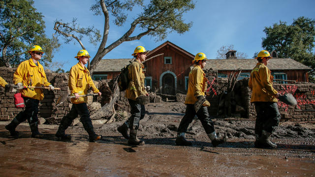 Rescue workers enter properties to look for missing persons after a mudslide in Montecito, California, 