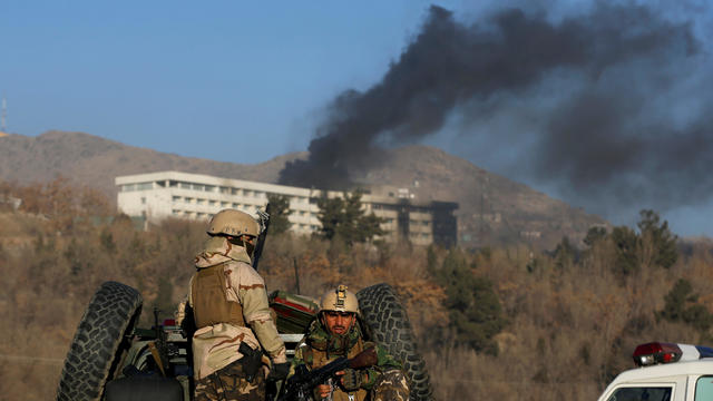 Afghan security forces keep watch as smoke rises from the Intercontinental Hotel in Kabul,ÊAfghanistan 