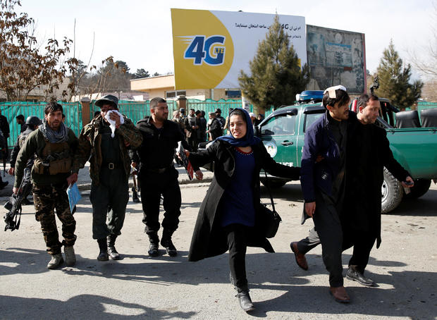 Afghan security forces members and civilians assist the injured after a blast in Kabul 