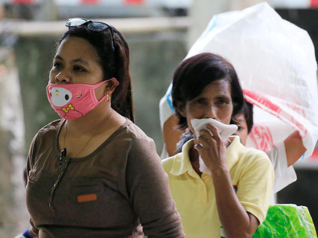 A resident wearing a face mask waits for relief goods after Mayon Volcano erupted at Camalig 